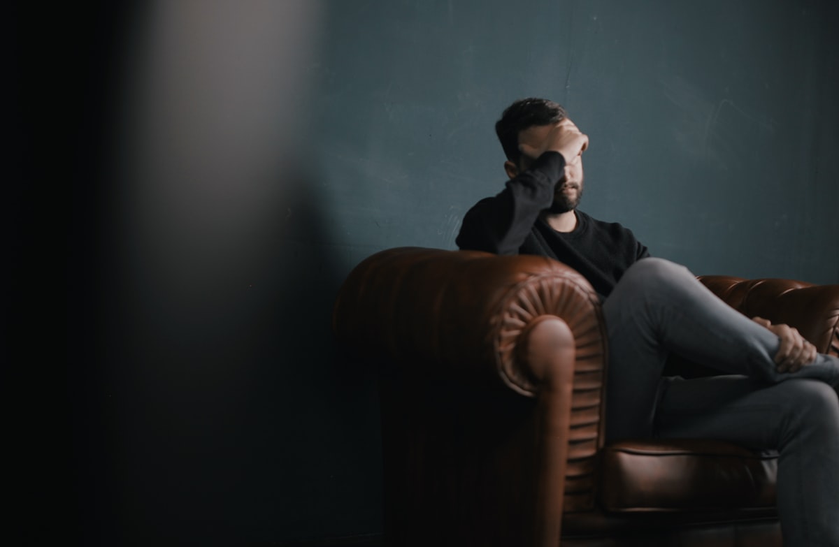 Person sitting with a hand over their chest, illustrating anxiety