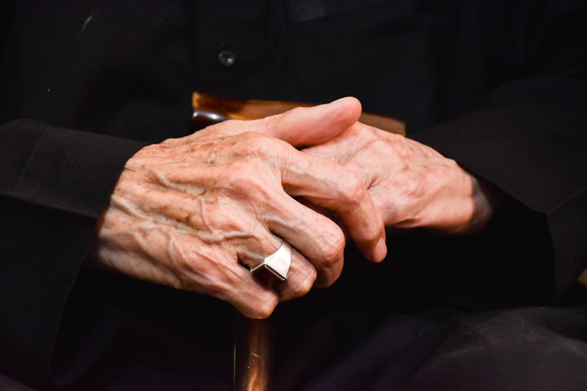 Person massaging their own stiff, arthritic hand joints