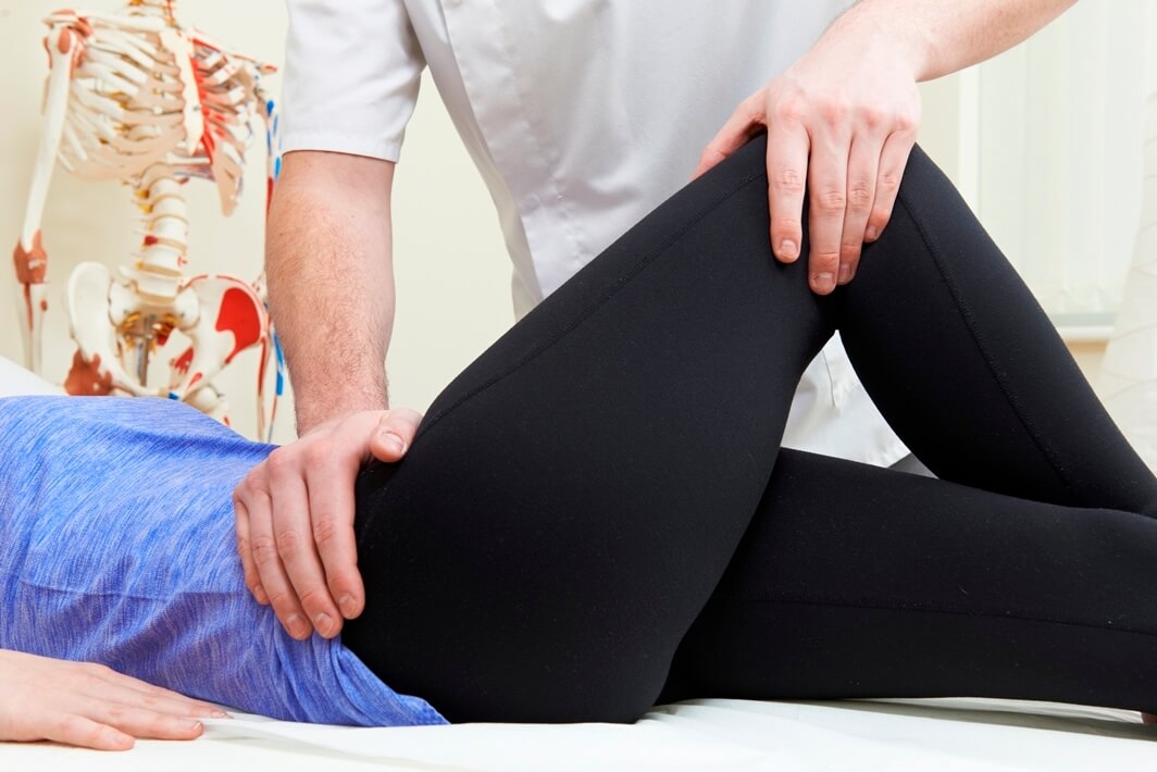 Therapist applying deep pressure therapy to a client's hip to relieve hip pain