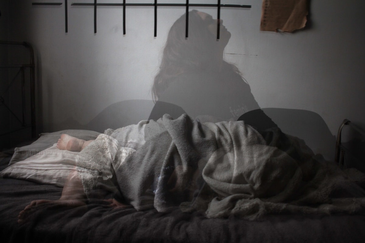 Person lying awake in bed struggling with insomnia
