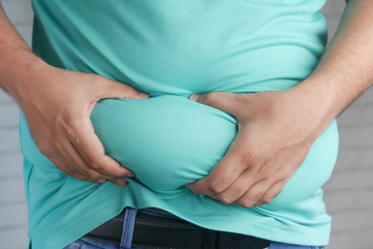 Person holding their stomach in discomfort, illustrating digestive issues