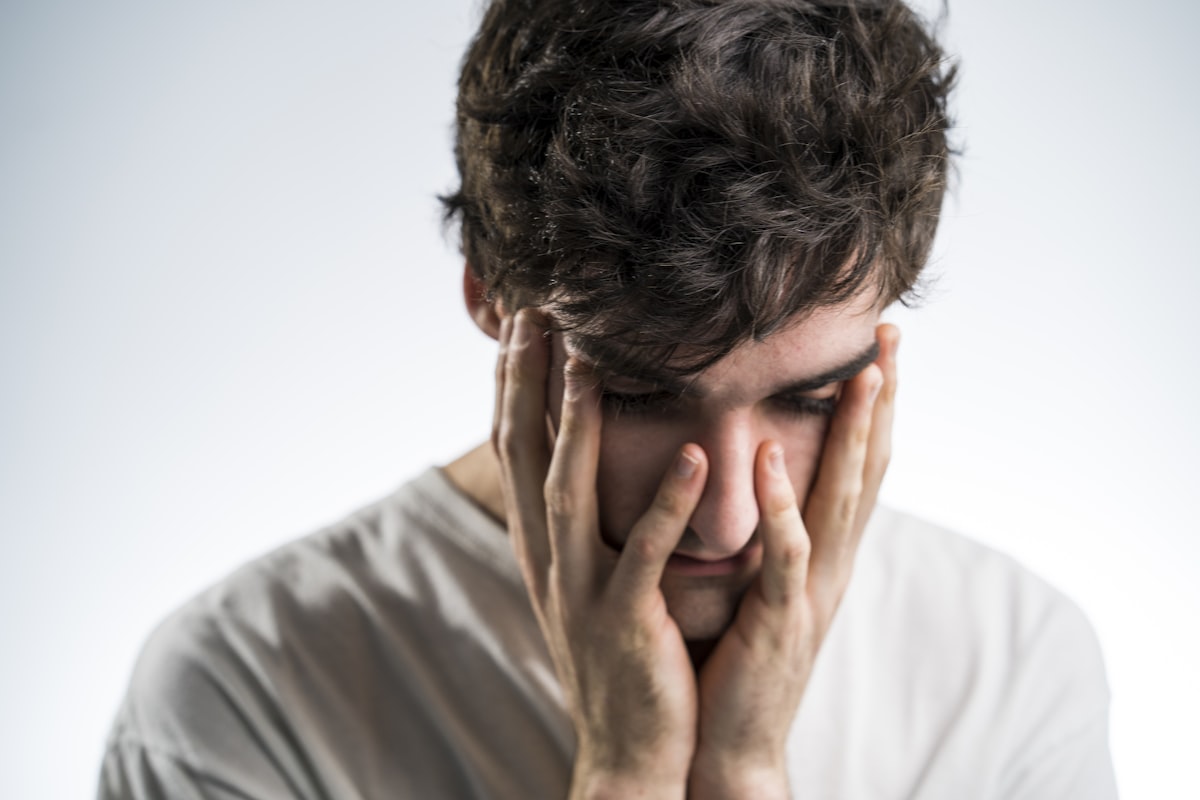 Person holding their jaw in pain, illustrating TMJ dysfunction
