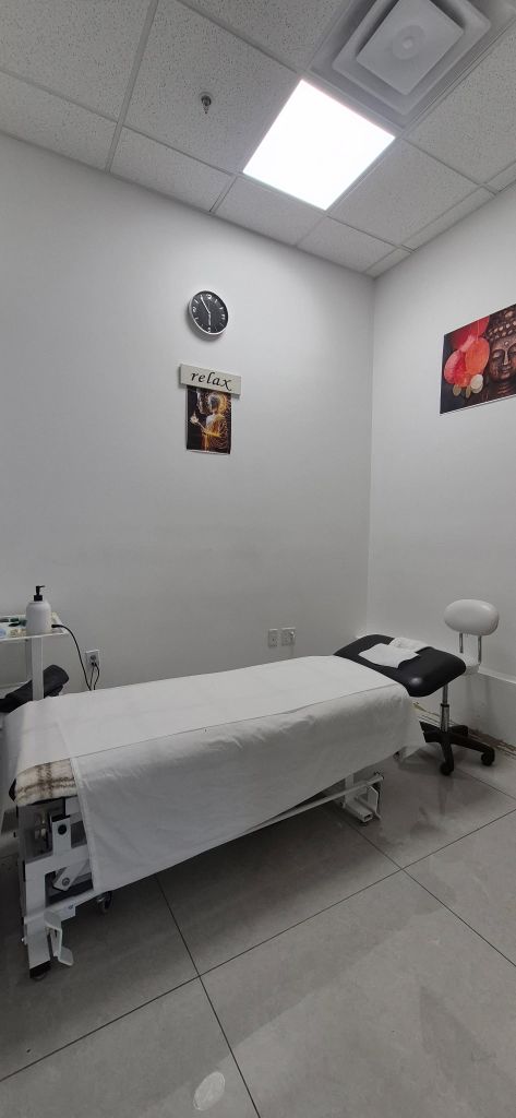 Quiet treatment room with a Buddha wall art and therapy table