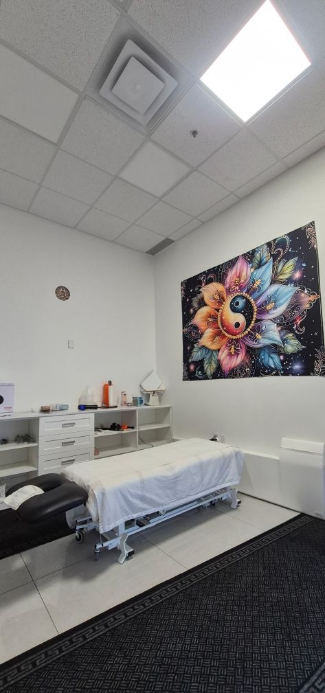 Treatment room with a colourful yin-yang mandala wall art above the therapy table